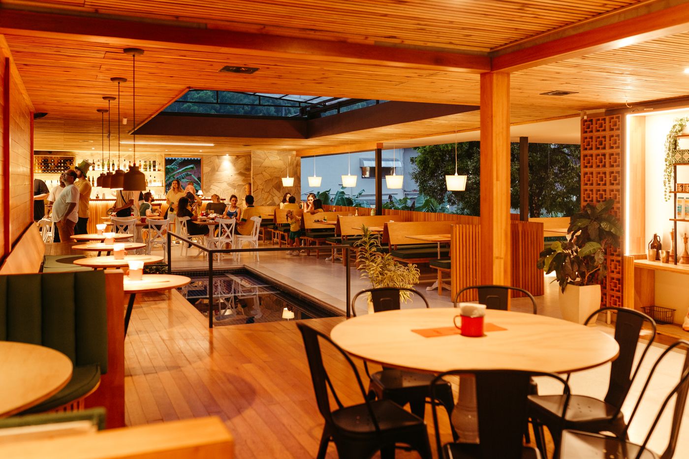 Interiér restaurace s dřevěným dekorem a teplým atmosférickým osvětlením